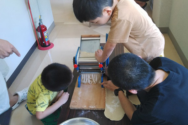 お父さんとうどん作りを楽しむ子どもたち