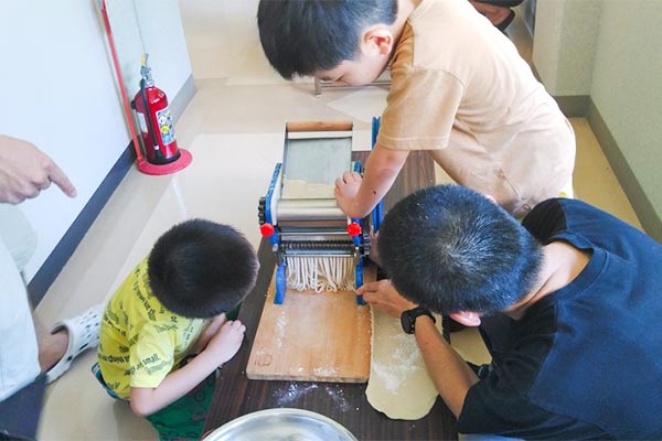 お父さんとうどん作りを楽しむ子どもたち